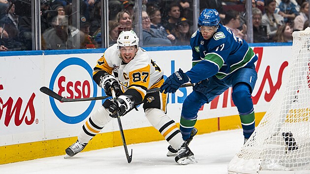 Filip Chytil z Vancouver Canucks se sna�� zpomalit Sidneyho Crosbyho z Pittsburgh Penguins.