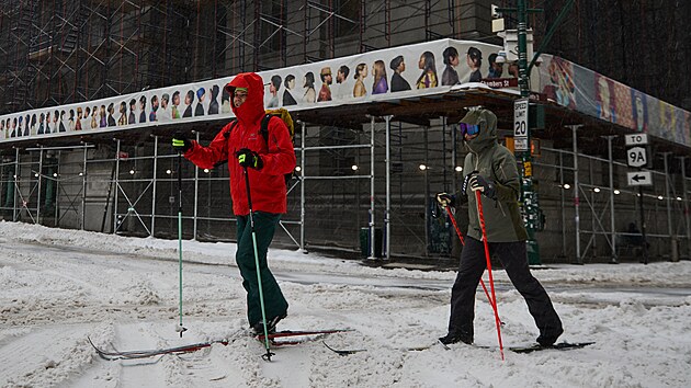 Lid� proch�zej� doln�m Manhattanem v New Yorku s ly�emi na nohou. (25. ledna 2026)