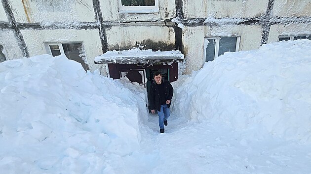 Mu� vych�z� z bytov�ho domu obklopen�ho sn�hov�mi z�v�jemi pot�, co extr�mn� sn�hov� bou�e zas�hla m�sto Petropavlovsk-Kam�atskij na D�ln�m v�chod� Ruska. (17. ledna 2026)