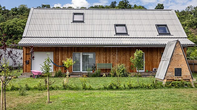 D�m m� tvar jednoduch�ho kv�dru s klasickou sedlovou st�echou se sklonem 45�, podkrov� a v�raznou horizont�ln� terasu. Zahradn� dome�ek pro dcerky je postaven� ze zbytk� stavby.