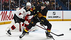 Filip Chytil z Vancouveru se sna�í udr�et puk p�ed Dougiem Hamiltonem z New...