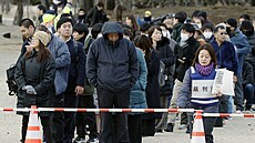 Lidé stojí v �ad�, aby získali lístky do loterie o místa v soudní síni p�ed...