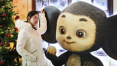 �ena v Moskv� pózuje s figurínou filmové postavy �ebura�ka. (31. prosince 2025)