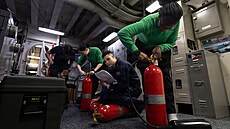 Námo�níci amerického námo�nictva provád�jí údr�bu nádob s CO2 na palub�...