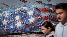 Íránci v Teheránu procházejí kolem státní budovy pokryté protizápadním...