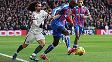 Úto�ník Jean-Philippe Mateta z Crystal Palace si kryje mí� p�ed Markem...