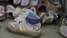 Podél chodby jsou rozestavené boty, které si d�ti nesta�ily nazout, kdy� jejich...