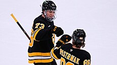 Charlie McAvoy se raduje s Davidem Pastr�ákem z branky Bostonu.