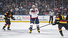 Alexander Ove�kin se natahuje po kotou�i, vpravo ho sleduje Filip Hronek.