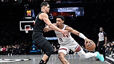 Ryan Dunn (0) z Phoenix Suns úto�í v duelu s Brooklyn Nets, brání ho Michael...