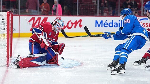 Jakub Dobe� (75) z Montreal Canadiens vyr�� puk v z�pase s Colorado Avalanche, neprosadil se Martin Ne�as (88).