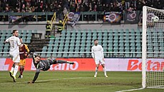 Branká� Rihards Matrevics z Dukly a fotbalisté Sparty sledují st�elu Luká�e...