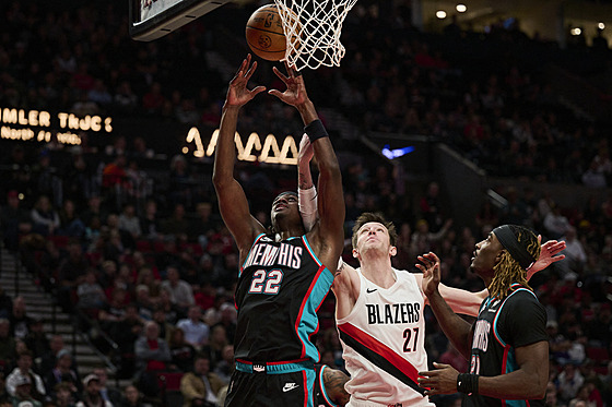 Taylor Hendricks (vlevo) z Memphisu chytá odra�ený mí�, po kterém se natahuje i...