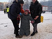 Sousedé pomáhají �en� poté, co dron zasáhl její byt v Charkov�. (3. února 2026)