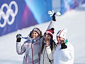 Snowboardistka Zuzana Mad�rová (uprost�ed) se zakusuje do zlaté medaile.