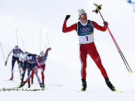 Johannes Hösflot Klaebo slaví triumf ve skiatlonu na hrách v Itálii.