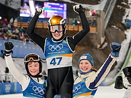 Vít�zná skokanka na ly�ích Anna Odine Strömová se raduje se svými týmovými...