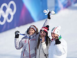 Snowboardistka Zuzana Mad�rová (uprost�ed) se zakusuje do zlaté medaile.