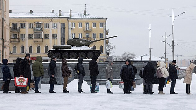 Lid� �ekaj� v mraziv�m po�as� na autobusov� zast�vce v Charkov�. (31. ledna...