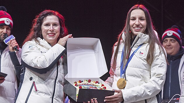 Snowboardistku Zuzanu Mad�rovou, kter� z�skala na olympijsk�ch hr�ch v It�lii zlatou medaili v paraleln�m ob��m slalomu, p�iv�tali fanou�ci na �eskobud�jovick�m Olympijsk�m festivalu. Na sn�mku medailistka p�eb�r� dort s vlastn� podobiznou od prim�torky m�sta Dagmar �kodov� Parmov�. (9. �nora 2026)