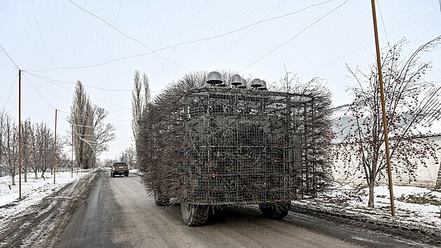 Vojensk� auto oplocen� elektrickou s�t� na silnici s protidronovou s�t� v Don�ck� oblasti (23. ledna 2026)