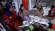 Záchraná�i evakuují obyvatele z bytového domu zasa�eného ruským dronem v...