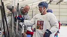 Martin Ne�as si vybírá na tréninku hokejky, pomáhá mu kustod Petr �ulan.