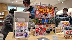 Náv�t�vníci si prohlí�ejí suvenýry s motivem japonské premiérky Sanae...