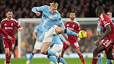 Úto�ník Manchesteru CIty Erling Haaland se natahuje po balon v utkání s...