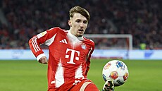 Zálo�ník Bayernu Lennart Karl si zpracovává mí� v utkání s Hoffenheimem.