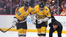 Charlie McAvoy (73) z Boston Bruins se zranil, jeho spoluhrá� David Pastr�ák...