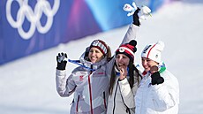 Snowboardistka Zuzana Mad�rová (uprost�ed) se zakusuje do zlaté medaile.