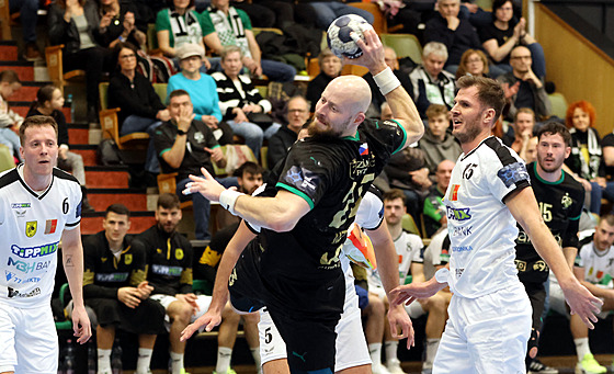 Pivot karvinských házenká�� Jan U�ek se protla�il ke st�ele.