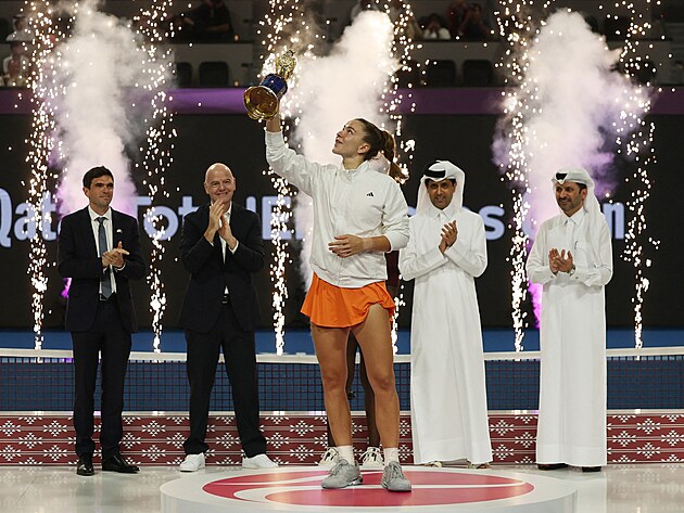 Karol�na Muchov� p�zuje s trofej� pro �ampionku turnaje v Dauh�. Za n� (druh�...