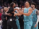 Brandon Miller a Grant Williams (2) z Charlotte Hornets krotí svého trenéra...