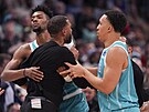 Brandon Miller (24) a Grant Williams (2) z Charlotte Hornets krotí svého...