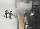 Pracovníci �istí svah b�hem silného sn�ení p�ed finále v �enském freestylovém...