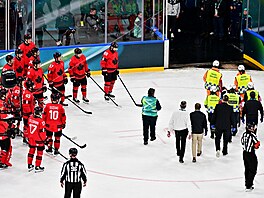 Kanad�tí hokejisté sledují, jak léka�i odvá�í �výcarského úto�níka Kevina Fialu...