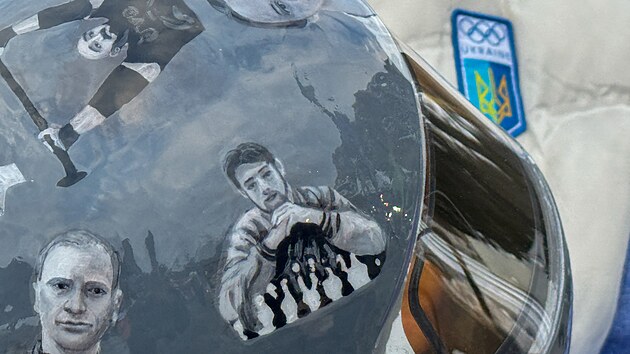 Ukrajinsk� skeletonista Vladyslav Heraskevy� na olympijsk� dr�ze v Cortin� d�Ampezzo v helm�, na n� jsou fotografie lid� zabit�ch b�hem v�lky na Ukrajin�. (9. �nora 2026)