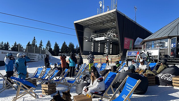 Apr�s-ski na krkono�sk� zp�sob. Turist� relaxuj� p�ed horn� stanic� lanovky.