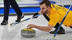 Oskar Eriksson ze �védska vysílá kámen v curlingovém zápase s Kanadou.