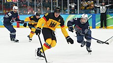 Tim Stutzle z N�mecka v akci s Julesem Boscqem z Francie. (17. února 2026)