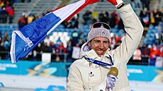 Zlatý medailista Quentin Fillon Maillet z Francie slaví s francouzskou vlajkou...