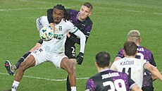 �t�pán Chaloupek ze Slavie t�sn� brání karvinského úto�níka Luckyho Ezeha.