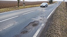 Silnice plná výtluk� nedaleko Ostrova�ic na Brn�nsku u dálnice D1. (únor 2026)