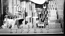 Pohled do výlohy lah�dká�ství Lippert v ulici Na Po�í�í se zbo�ím z UNRRY....