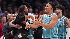 Brandon Miller a Grant Williams (2) z Charlotte Hornets krotí svého trenéra...