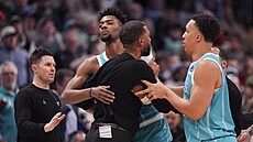 Brandon Miller (24) a Grant Williams (2) z Charlotte Hornets krotí svého...
