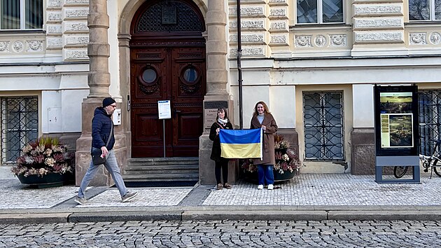 Ukrajinskou vlajku p�inesla ke vchodu radnice v Lounech (zleva) opozi�n� zastupitelka Ivana Hlu�t�kov� (Louny Spole�n�). K jej� iniciativ� se p�ipojila �t�p�nka Slez�kov� (ODS). (24. �nora 2026)