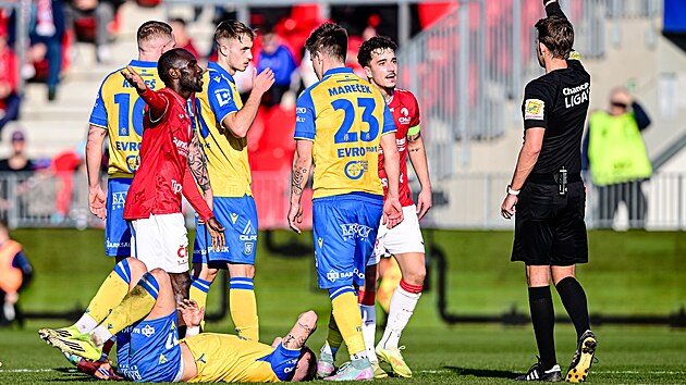 Diskuze pardubick�ch fotbalist� (v �erven�m) s rozhod��m Bene�em. Ten ud�luje �lutou kartu kapit�novi Vojt�chu Patr�kovi po faulu na teplick�ho protivn�ka.